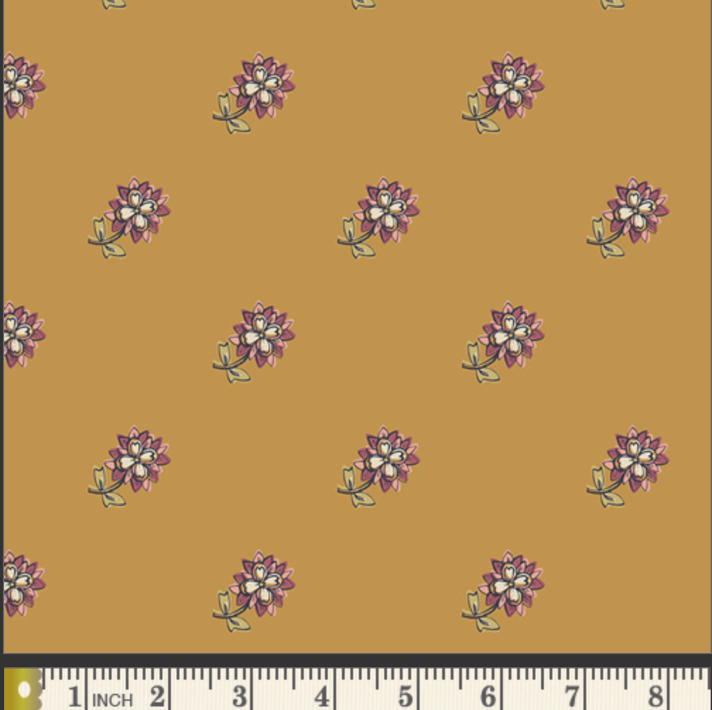 A repeating floral pattern on a warm mustard-yellow background, with small purple and white flowers and green stems. A ruler strip appears along the bottom edge for scale.