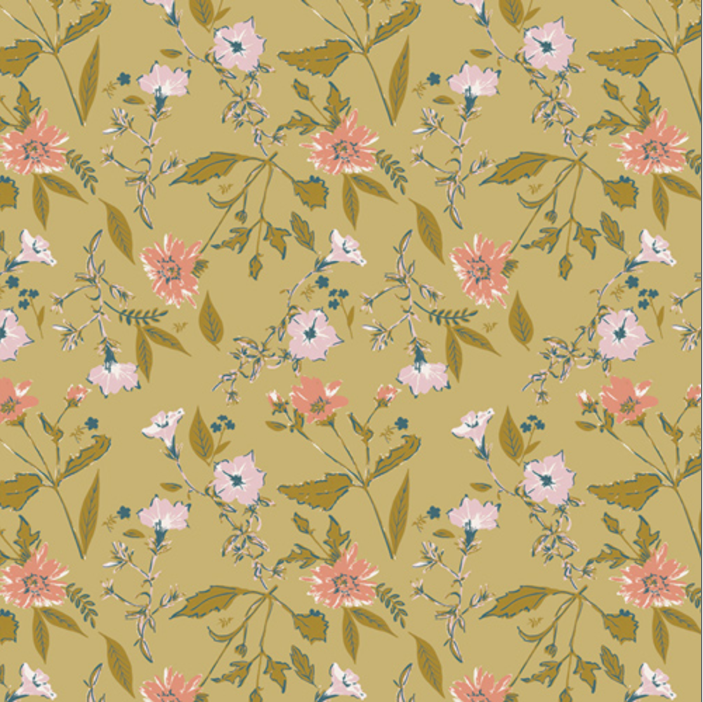 A close-up of a floral fabric pattern on a mustard yellow background, featuring pink flowers, light pink blossoms, and olive green leaves. A black ruler with white markings is visible along the bottom edge to show scale.