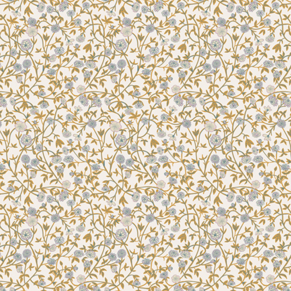 A close-up of a fabric pattern with a dense floral vine design in muted blue-gray and mustard-gold on a warm off-white background, with a measurement ruler along the bottom edge.