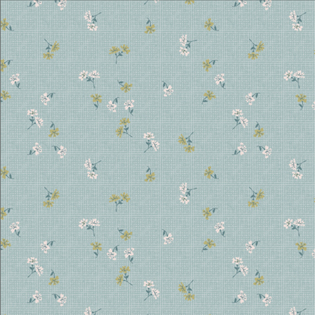 A fabric pattern swatch showing a light blue-green background with a small-scale floral print in white, yellow, and green, with a measuring ruler along the bottom edge.
