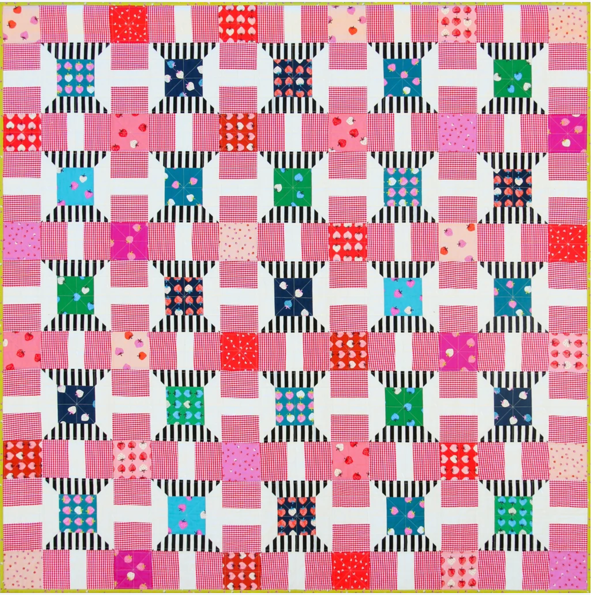 A colorful patchwork quilt featuring a repeating block pattern with pink, red, blue, green, and black-and-white striped fabrics on a white background.