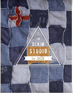 The image shows a quilt of blue denim fabric squares with a red accent in the top left corner. The text “The Denim Studio by AGF” is overlayed inside of a white triangle.