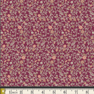 A close-up of a floral fabric pattern with small peach and beige flowers on a deep burgundy background, with a ruler along the bottom edge showing measurement scale.