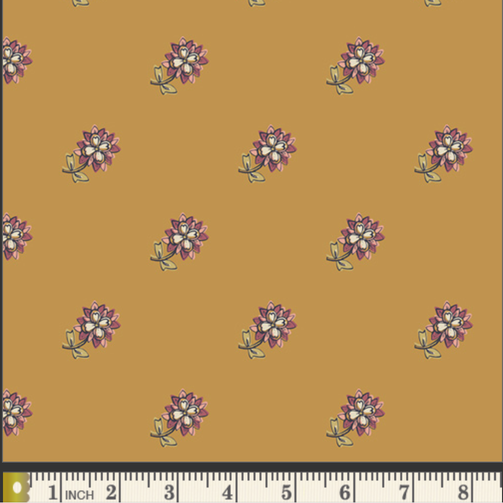 A repeating floral pattern on a warm mustard-yellow background, with small purple and white flowers and green stems. A ruler strip appears along the bottom edge for scale.