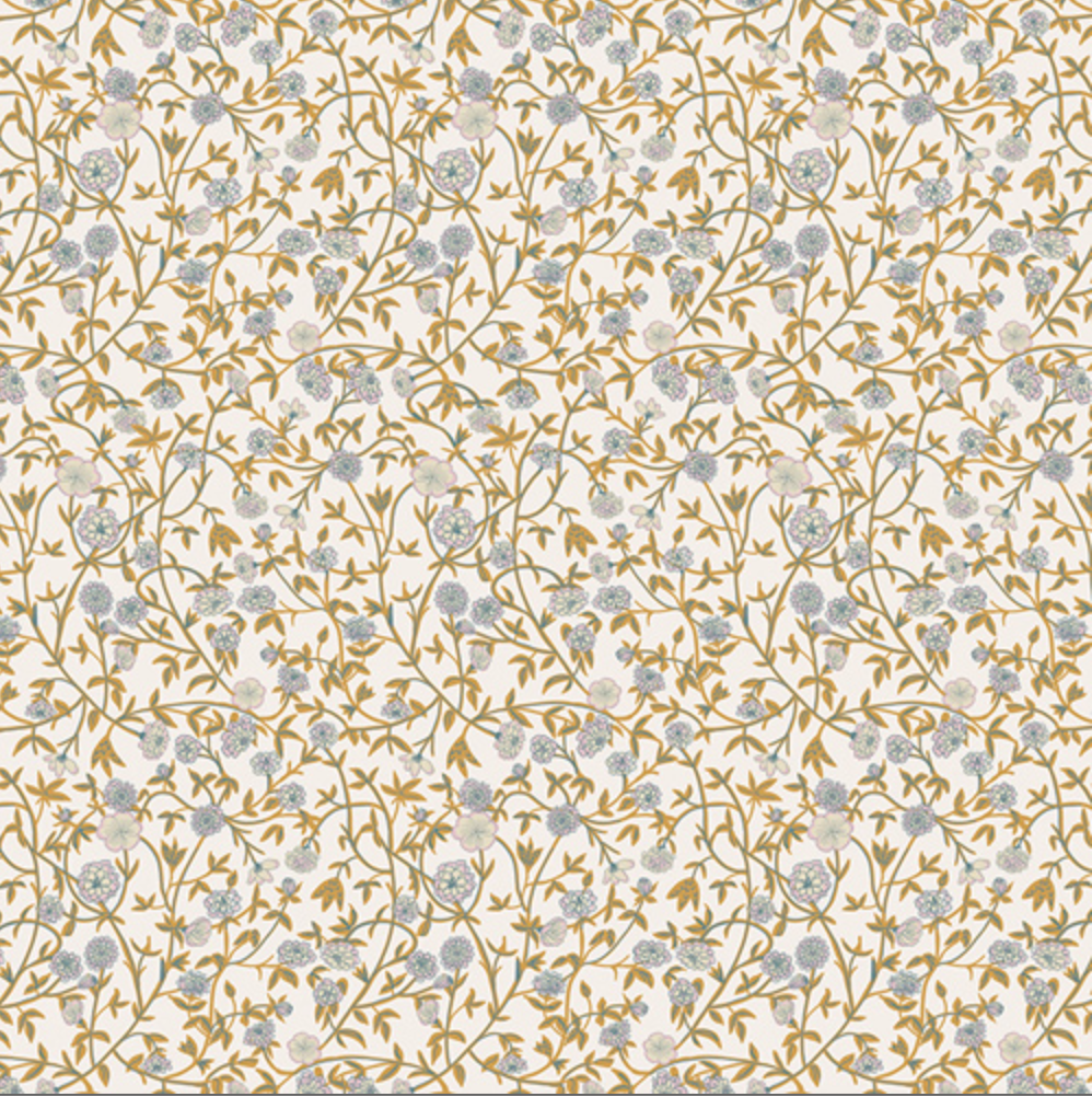 A close-up of a fabric pattern with a dense floral vine design in muted blue-gray and mustard-gold on a warm off-white background, with a measurement ruler along the bottom edge.
