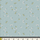 A fabric pattern swatch showing a light blue-green background with a small-scale floral print in white, yellow, and green, with a measuring ruler along the bottom edge.