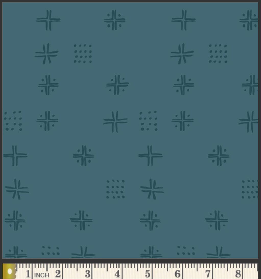 A close-up of a teal fabric pattern featuring repeating dark teal geometric motifs, with a cream-colored fabric ruler visible along the bottom edge for scale.