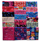 A grid of 19 folded fabric samples with various colorful patterns, including floral, geometric, and whimsical illustrations, displayed on a clean white background.
