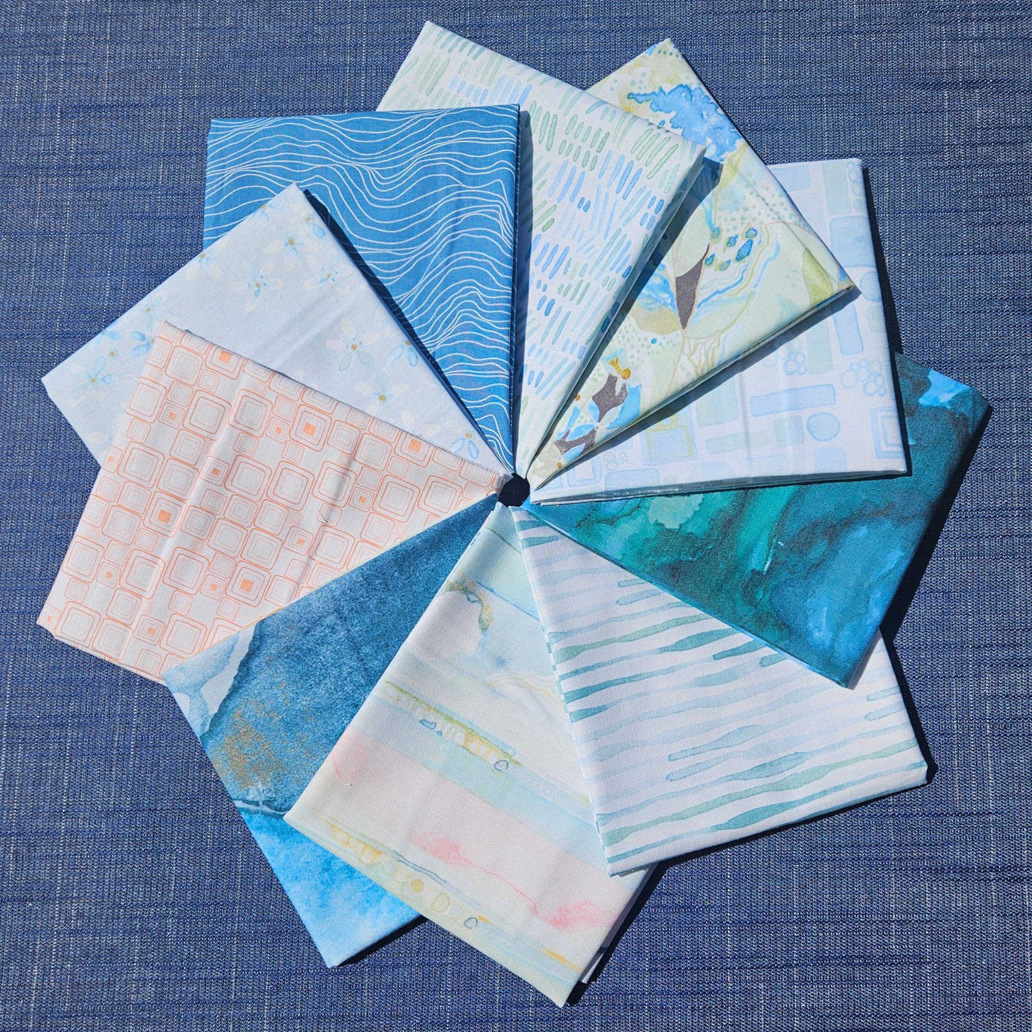 Collection of fabric swatches with various patterns on a blue textured background