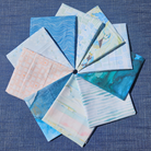 Collection of fabric swatches with various patterns on a blue textured background