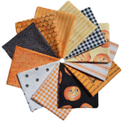 A fan arrangement of multiple Halloween-themed fabric squares in orange, black, white, and yellow patterns including pumpkins, gingham, stripes, and scalloped edges on a white background.